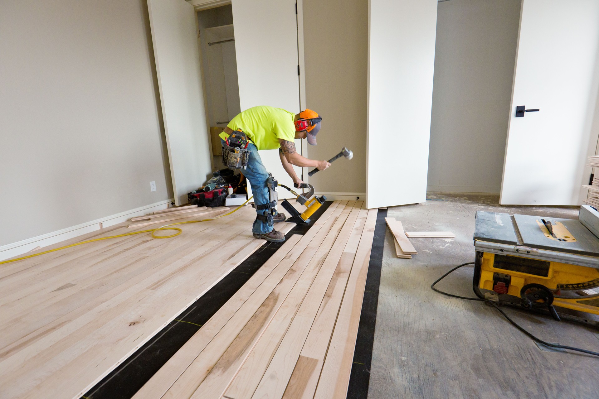 Installation of Maple Hardwood Flooring with Nail Gun in Progress